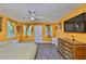 Comfortable bedroom features wood floors, a ceiling fan, a large dresser, and a television at 5840 39Th N St, St Petersburg, FL 33714