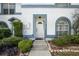 Inviting front entrance with a white door, trimmed in blue and complemented by lush landscaping at 603 Bainbridge Dr, Brandon, FL 33511