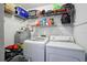 Laundry room with a washer, dryer, water heater, and shelving for storing laundry supplies at 603 Bainbridge Dr, Brandon, FL 33511