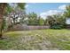 Large backyard with grass and a wooden fence for privacy at 607 E River Dr, Temple Terrace, FL 33617