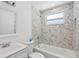Bright bathroom featuring white tile, a bathtub, and a window at 607 E River Dr, Temple Terrace, FL 33617