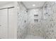 Modern bathroom featuring marbled tile shower with built-in shelving and sliding door at 607 E River Dr, Temple Terrace, FL 33617