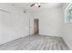 Bright bedroom features a ceiling fan, wood-look floors, and a closet for ample storage at 607 E River Dr, Temple Terrace, FL 33617
