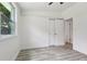 Bright bedroom with a large window, wood-look floors, and a closet for ample storage at 607 E River Dr, Temple Terrace, FL 33617