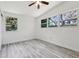 Bright bedroom features a ceiling fan, multiple windows, and wood-look floors at 607 E River Dr, Temple Terrace, FL 33617