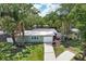 Charming single-story home with mature trees, a manicured lawn, and an inviting front entrance at 607 E River Dr, Temple Terrace, FL 33617