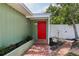 Inviting red front door framed by brick path, greenery, and fresh landscaping at 607 E River Dr, Temple Terrace, FL 33617
