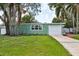 Charming single-story home with attached garage, green exterior, and well manicured lawn at 607 E River Dr, Temple Terrace, FL 33617