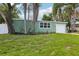Charming home with an attached garage, green exterior, manicured lawn, and mature shade trees at 607 E River Dr, Temple Terrace, FL 33617