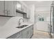 Modern kitchen featuring stone countertops, stainless appliances, and sleek gray cabinetry at 607 E River Dr, Temple Terrace, FL 33617