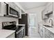 Well-equipped kitchen featuring stainless steel appliances, stone countertops, and gray cabinetry at 607 E River Dr, Temple Terrace, FL 33617