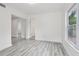 Clean room with light wood flooring, offering a glimpse into adjacent rooms and natural light at 607 E River Dr, Temple Terrace, FL 33617