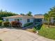 Charming single-story home with lush landscaping, a well-manicured lawn, and a welcoming driveway at 610 Cordova Ne Blvd, St Petersburg, FL 33704