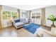 Bright living room with hardwood floors, a gray sofa, and large windows offering natural light at 610 Cordova Ne Blvd, St Petersburg, FL 33704