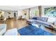 Open-concept living area with hardwood floors, gray sofa, and a seamless flow to dining area at 610 Cordova Ne Blvd, St Petersburg, FL 33704