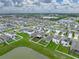 Aerial view of home showcasing a fenced yard, landscaping, and a serene pond in a well-planned community at 636 Olive Conch St, Ruskin, FL 33570