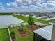 Overhead view of a landscaped backyard with white fencing, a pond, and neighboring houses at 636 Olive Conch St, Ruskin, FL 33570