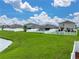 Spacious backyard features lush green grass, white fencing, and a glimpse of the serene pond at 636 Olive Conch St, Ruskin, FL 33570