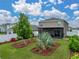 Landscaped backyard featuring lush grass, a garden, white fence and screened in patio at 636 Olive Conch St, Ruskin, FL 33570
