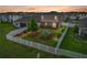 Aerial backyard view of a well-maintained lawn, white fence, and beautiful landscaping at sunset at 636 Olive Conch St, Ruskin, FL 33570