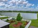 Beautiful backyard featuring manicured landscaping, mulched flower beds, and a scenic water view at 636 Olive Conch St, Ruskin, FL 33570