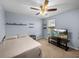 Cozy bedroom featuring a ceiling fan, a TV, shelving and a window with natural light at 636 Olive Conch St, Ruskin, FL 33570