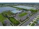 Aerial view of a community clubhouse, playground, pool, and parking lot, with lake views and palm trees at 636 Olive Conch St, Ruskin, FL 33570