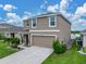 Inviting two-story home features a well-kept lawn, lush landscaping and a two-car garage at 636 Olive Conch St, Ruskin, FL 33570