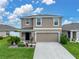 Charming two-story home with a two-car garage, green lawn and lovely landscaping at 636 Olive Conch St, Ruskin, FL 33570