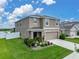 Well-manicured lawn and landscaping enhance the curb appeal of this inviting two-story home at 636 Olive Conch St, Ruskin, FL 33570