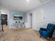Comfortable upstairs hallway featuring carpeted floors, a mounted television and a blue accent chair at 636 Olive Conch St, Ruskin, FL 33570