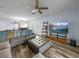 Comfortable living room with hardwood floors, ceiling fan, large television and decorative shelving at 636 Olive Conch St, Ruskin, FL 33570