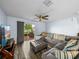 Comfortable living room with stylish sectional sofa, ceiling fan, and sliding glass doors to the patio at 636 Olive Conch St, Ruskin, FL 33570