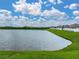Relaxing pond view with green lawn, a white fence, and peaceful waters at 636 Olive Conch St, Ruskin, FL 33570