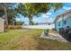Spacious backyard featuring a white fence, lush green grass, and mature trees offering shade at 6704 70Th N Ave, Pinellas Park, FL 33781