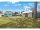 A large backyard with a shed, surrounded by trees, grass, and blue skies at 6704 70Th N Ave, Pinellas Park, FL 33781