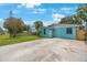 A cozy, blue-painted single-story house featuring a well-kept lawn and concrete driveway at 6704 70Th N Ave, Pinellas Park, FL 33781