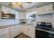 Updated kitchen features white cabinets, granite countertops, stainless steel appliances, and modern lighting at 6704 70Th N Ave, Pinellas Park, FL 33781
