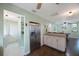 Open concept living space with stainless fridge, dining area, kitchen storage and laminate floors at 6704 70Th N Ave, Pinellas Park, FL 33781