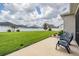 A serene backyard featuring lush green grass, a white fence, and comfortable patio furniture for relaxing outdoors at 6879 Talamore Dr, Wesley Chapel, FL 33545