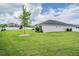 Lush backyard featuring a green lawn, complemented by a white fence, offering a serene outdoor space at 6879 Talamore Dr, Wesley Chapel, FL 33545