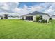 Backyard with a healthy lawn, white fence, and a screened-in lanai at 6879 Talamore Dr, Wesley Chapel, FL 33545