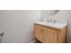 Powder room featuring wood vanity with marble countertop and stainless steel faucet at 6879 Talamore Dr, Wesley Chapel, FL 33545