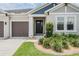 Inviting front entrance with a well-manicured lawn and neat landscaping leading up to a dark front door at 6879 Talamore Dr, Wesley Chapel, FL 33545