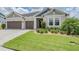 Charming single-Gathering home featuring a well-manicured lawn, neat landscaping, and a three-car garage at 6879 Talamore Dr, Wesley Chapel, FL 33545