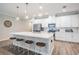 Modern kitchen featuring a large island with seating, stainless steel appliances, and white cabinets at 6879 Talamore Dr, Wesley Chapel, FL 33545