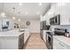 Spacious kitchen with white cabinetry, stainless appliances, quartz countertops and modern pendant lighting at 6879 Talamore Dr, Wesley Chapel, FL 33545