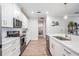 Modern kitchen featuring white cabinets, stainless steel appliances and island with quartz countertops at 6879 Talamore Dr, Wesley Chapel, FL 33545