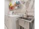 Functional laundry room with a utility sink, modern appliances, and convenient storage solutions at 6879 Talamore Dr, Wesley Chapel, FL 33545
