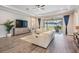 Comfortable living room with a tray ceiling, luxury vinyl flooring and large sliding glass doors at 6879 Talamore Dr, Wesley Chapel, FL 33545